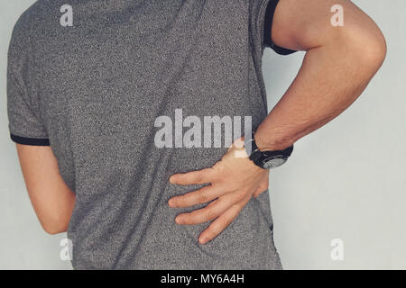 Close up di un uomo con il suo indietro nel dolore. malati rene. dolore nei reni. insufficienza renale. paziente trattiene la sua mano dietro la schiena. artrosi, chondr Foto Stock
