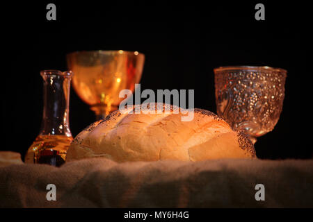 Pane vino santo acqua benedetta sulla tabella per la liturgia di Pasqua Santa Messa con bella illuminazione calda. Immagine di simboli cristiani, religione e tradizione. La quaresima Foto Stock