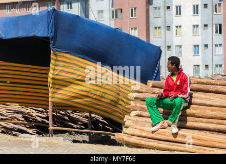 Etiopia ad Addis Abeba, 30 gennaio 2014, uomo seduto su una pila di impalcatura di legno tavole Foto Stock