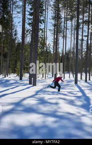 Giovane ragazzo in esecuzione coperta di neve paesaggio rurale Foto Stock