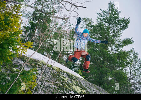 Ragazzo giovane jumping nel paesaggio rurale e a basso angolo di visione Foto Stock