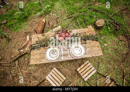 Bel posto in una zona boscosa con un tavolo da picnic prevista per una cena romantica Foto Stock