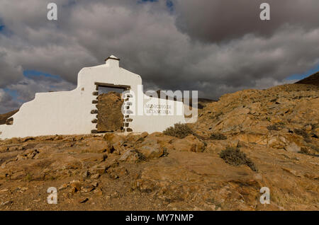 Betancuria ingresso monumento su Fuerteventura Isole Canarie con tempestoso cielo drammatico e un paesaggio arido Foto Stock
