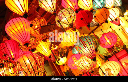 Rosso Arancione Rosa tradizionale giallo lanterne pendenti di notte nel mercato asiatico. Illuminazione e luminosa luce calda mostra reale e Asia Vietnam Foto Stock