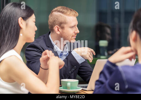 Un gruppo di imprenditori, avente incontro presso il cafe, all'aperto Foto Stock