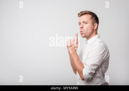 Uomo caucasico in maglia bianca fingendo che ha una connessione DUN in mani. Foto Stock