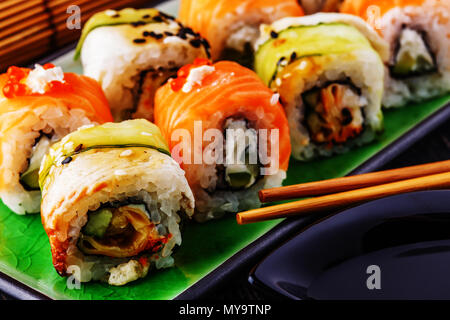 Sushi set: rotolo di sushi con salmone e sushi roll con anguilla affumicata, il fuoco selettivo. Foto Stock