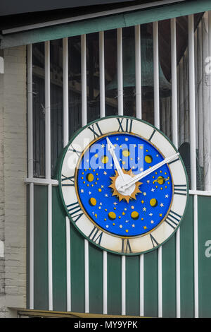 Orologio e campana su una parete in Corporation street shopping center presso la città di Corby, Northamptonshire, Inghilterra. Foto Stock