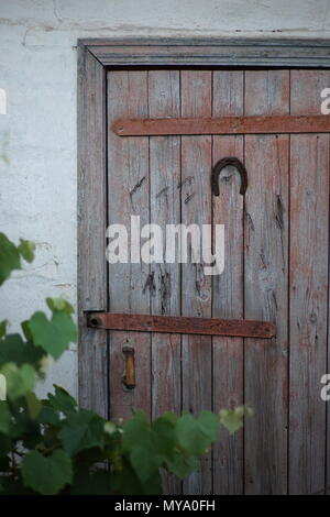 Il ferro di cavallo si blocca sulla vecchia porta - un simbolo di felicità e di una protezione contro le forze del male Foto Stock