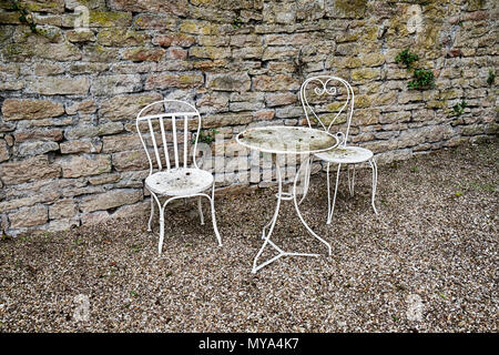 Un tavolo bianco e due sedie formano una bella zona tranquilla in un piccolo giardino corte nella città di Beaune in Borgogna Francia. Foto Stock