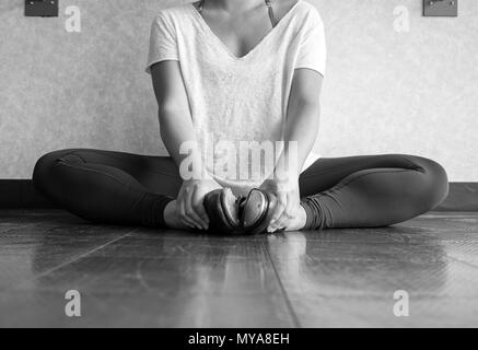 Versione in bianco e nero di toccare la ballerina in fase di riscaldamento e stretching prima di classe di danza Foto Stock