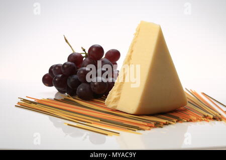 Una fetta di formaggio accanto ad alcune uve Foto Stock