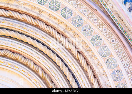 Particolare della facciata del duomo di Orvieto, Umbria, Italia. Spirale di colonne in marmo decorato con mosaici al di sopra della porta principale Foto Stock