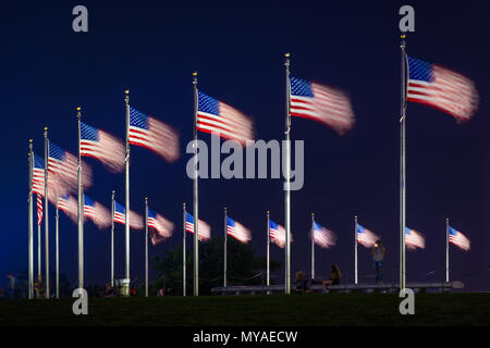 Bandierine americane presso il Monumento di Washington di notte, a Washington, DC. Foto Stock