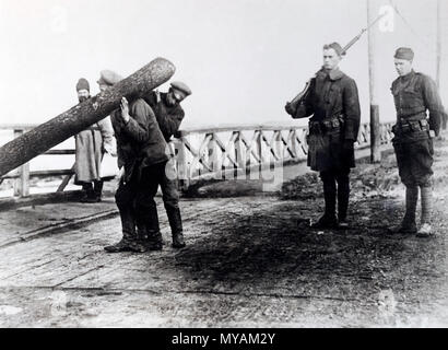 Prigionieri bolscevichi ad arcangelo, russo messi al lavoro. Prigionieri catturati dagli americani in arcangelo, tenendo big log da tagliare per il carburante per la Croce Rossa ospedale di Arcangelo. Essi sono sorvegliati da due soldati americani 1918 o 1919 Foto Stock