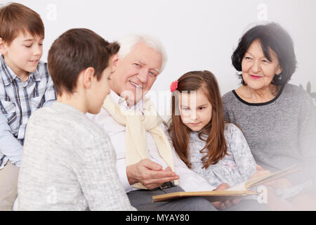 La famiglia felice guardando un vecchio album di foto Foto Stock