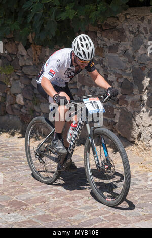 Greco ciclista maschio compete in una gara internazionale di mountain bike nel corso della foresta al di fuori del villaggio greco di molivos sull isola di Lesbo Foto Stock