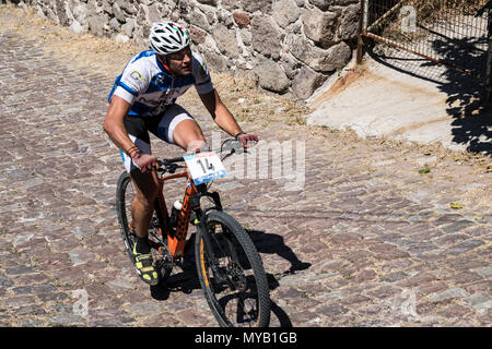 Greco ciclista maschio compete in una gara internazionale di mountain bike nel corso della foresta al di fuori del villaggio greco di molivos sull isola di Lesbo Foto Stock