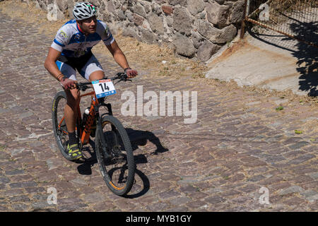 Greco ciclista maschio compete in una gara internazionale di mountain bike nel corso della foresta al di fuori del villaggio greco di molivos sull isola di Lesbo Foto Stock