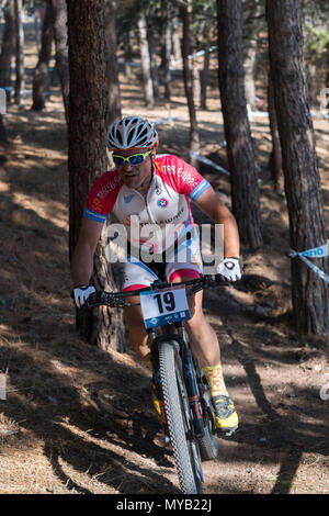 Greco ciclista maschio compete in una gara internazionale di mountain bike nel corso della foresta al di fuori del villaggio greco di molivos sull isola di Lesbo Foto Stock