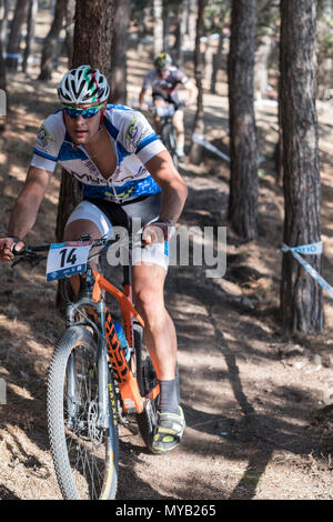 Greco ciclista maschio compete in una gara internazionale di mountain bike nel corso della foresta al di fuori del villaggio greco di molivos sull isola di Lesbo Foto Stock