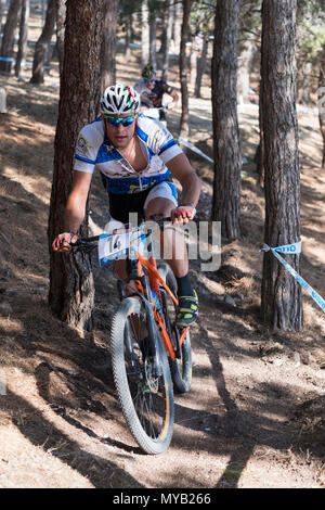 Greco ciclista maschio compete in una gara internazionale di mountain bike nel corso della foresta al di fuori del villaggio greco di molivos sull isola di Lesbo Foto Stock