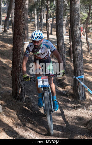 Greco ciclista maschio compete in una gara internazionale di mountain bike nel corso della foresta al di fuori del villaggio greco di molivos sull isola di Lesbo Foto Stock