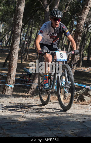 Greco ciclista maschio compete in una gara internazionale di mountain bike nel corso della foresta al di fuori del villaggio greco di molivos sull isola di Lesbo Foto Stock