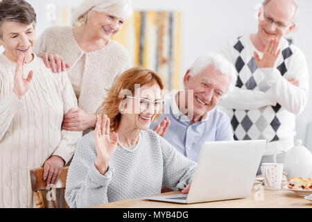 Anziani le persone felici parlando online tramite il laptop con il vecchio amico Foto Stock