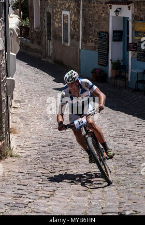 Ciclista greco compete in una gara internazionale di mountain bike nel villaggio greco di molivos sull isola di Lesbo Foto Stock