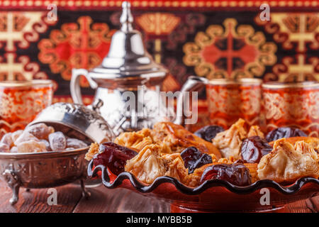 Marocchino tè alla menta in occhiali tradizionali con dolci, il fuoco selettivo. Foto Stock