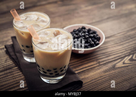 Latte in casa del tè di bolla con perle di tapioca su sfondo di legno Foto Stock