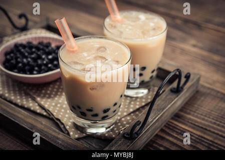 Latte in casa del tè di bolla con perle di tapioca su sfondo di legno Foto Stock