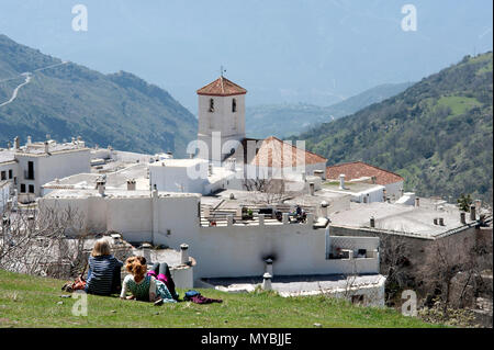 I turisti per godersi il sole e la vista panoramica del villaggio Alpujarran di Capileira in alto nelle montagne della Sierra Nevada in Spagna in Andalusia. Foto Stock