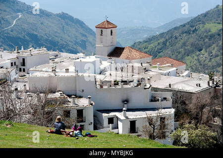 I turisti per godersi il sole e la vista panoramica del villaggio Alpujarran di Capileira in alto nelle montagne della Sierra Nevada in Spagna in Andalusia. Foto Stock