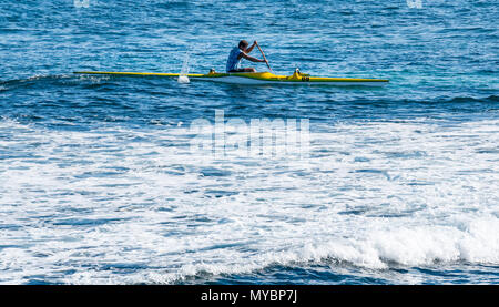 Locale uomo polinesiano paddling veloce in canoa outrigger in Oceano Pacifico, Hanga Roa, Isola di Pasqua, Cile Foto Stock