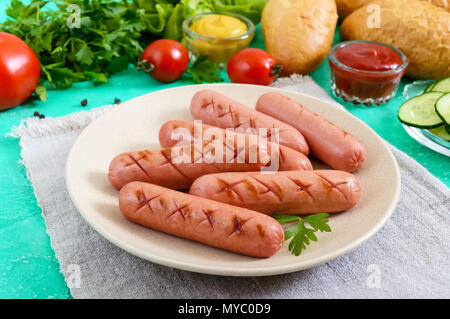 Succosa salsicce alla griglia, verdure fresche, verdi e croccanti panini su uno sfondo luminoso. Vista dall'alto. Ingredienti per hot dogs. Lay piatto. Foto Stock