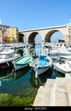 Il piccolo porto di pesca del Vallon des Auffes da una mattina di sole con i tradizionali e moderne imbarcazioni, cabanons e il ponte stradale in background. Foto Stock