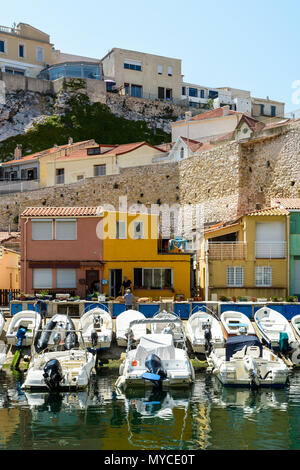 Il piccolo porto del Vallon des Auffes a Marsiglia da una mattina di sole con barche ormeggiate di fronte cabanons colorati e case sotto la scogliera. Foto Stock