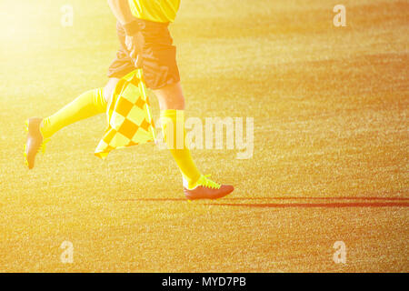 Arbitro assistente in movimento lungo il diversivo durante una partita di calcio Foto Stock