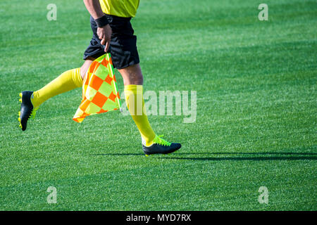 Arbitro assistente in movimento lungo il diversivo durante una partita di calcio Foto Stock