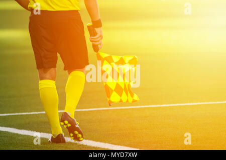 Arbitro assistente in movimento lungo il diversivo durante una partita di calcio Foto Stock