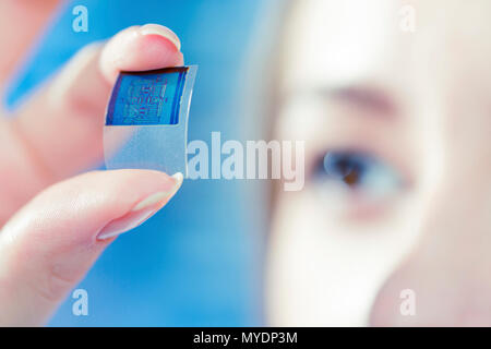 Esame tecnico di microchip nel laboratorio di microelettronica. Foto Stock