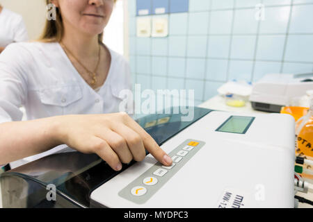 Tecnico utilizzando una PCR (reazione a catena della polimerasi) macchina per amplificare segmenti di DNA (acido desossiribonucleico). Foto Stock