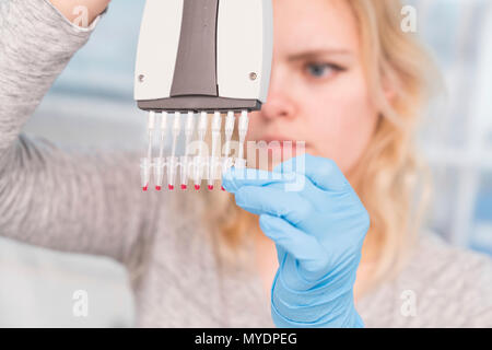 Tecnico utilizzando multipipette. Foto Stock