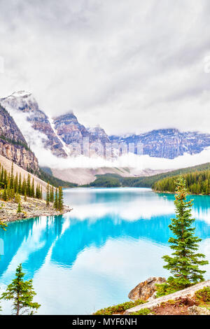 Nebbia e nuvole scendono sulla valle di dieci picchi dove alimentati da ghiacciai Lago Moraine cede il suo distinto blu turchese colore a causa della rifrazione di li Foto Stock