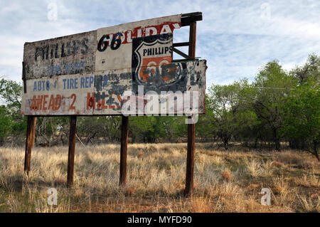 Un derelitti cartelloni pubblicitari un ex Phillips 66 garage è alla periferia della Route 66 città di Tucumcari, Nuovo Messico. Foto Stock