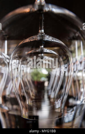 Righe di bicchieri di vino appesa in un ristorante bar. Foto Stock