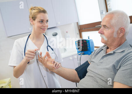 L'infermiera preparare un dispositivo fissato al dito Foto Stock