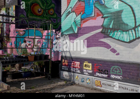 Graffiti artist dipinto sulle pareti dei nomadi giardini comunali spazio in Shoreditch, Brick Lane. London.UK Foto Stock